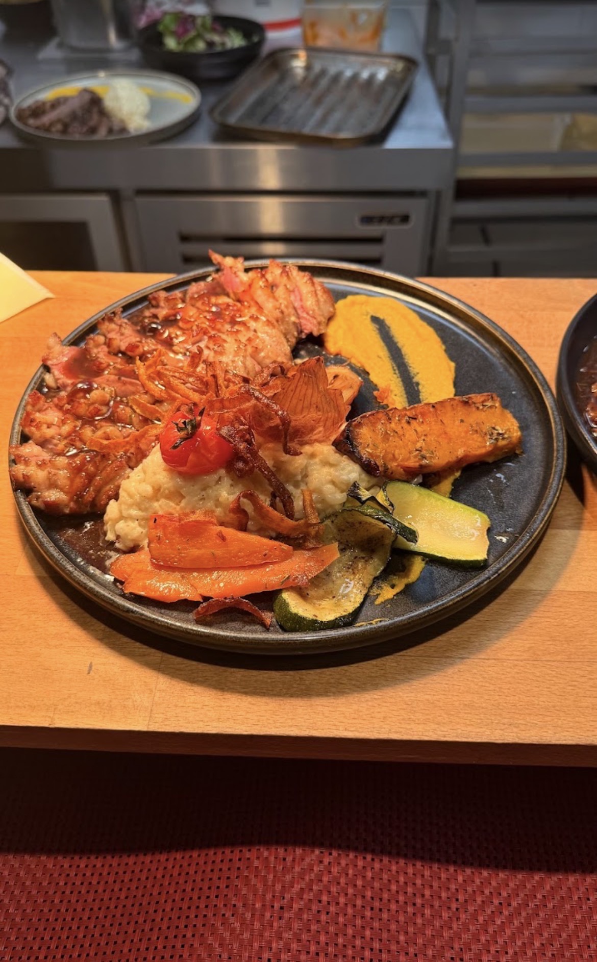Plat de viande grillée, risotto et légumes de saison
